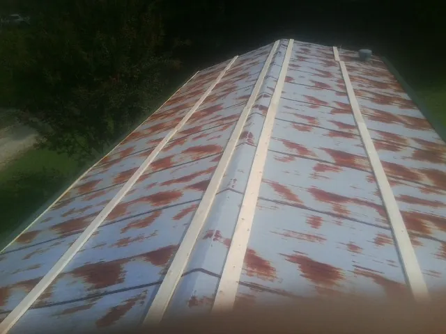 Rusted metal roof panels with new wood purlins before replacement — Storm Damage Roof Repair in Ray by Roofing Brothers